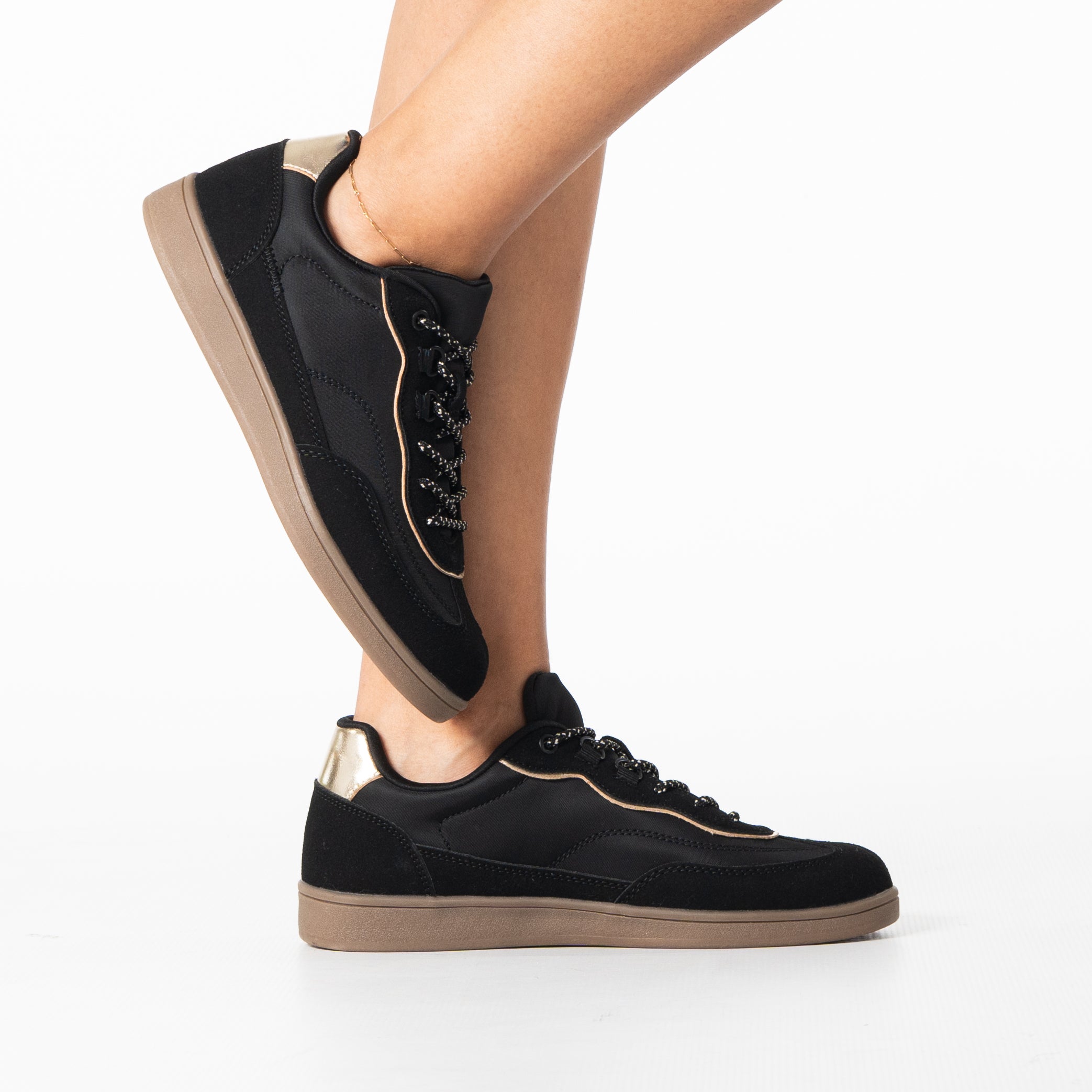 Uma women's sleek black sneaker with gold zip detail