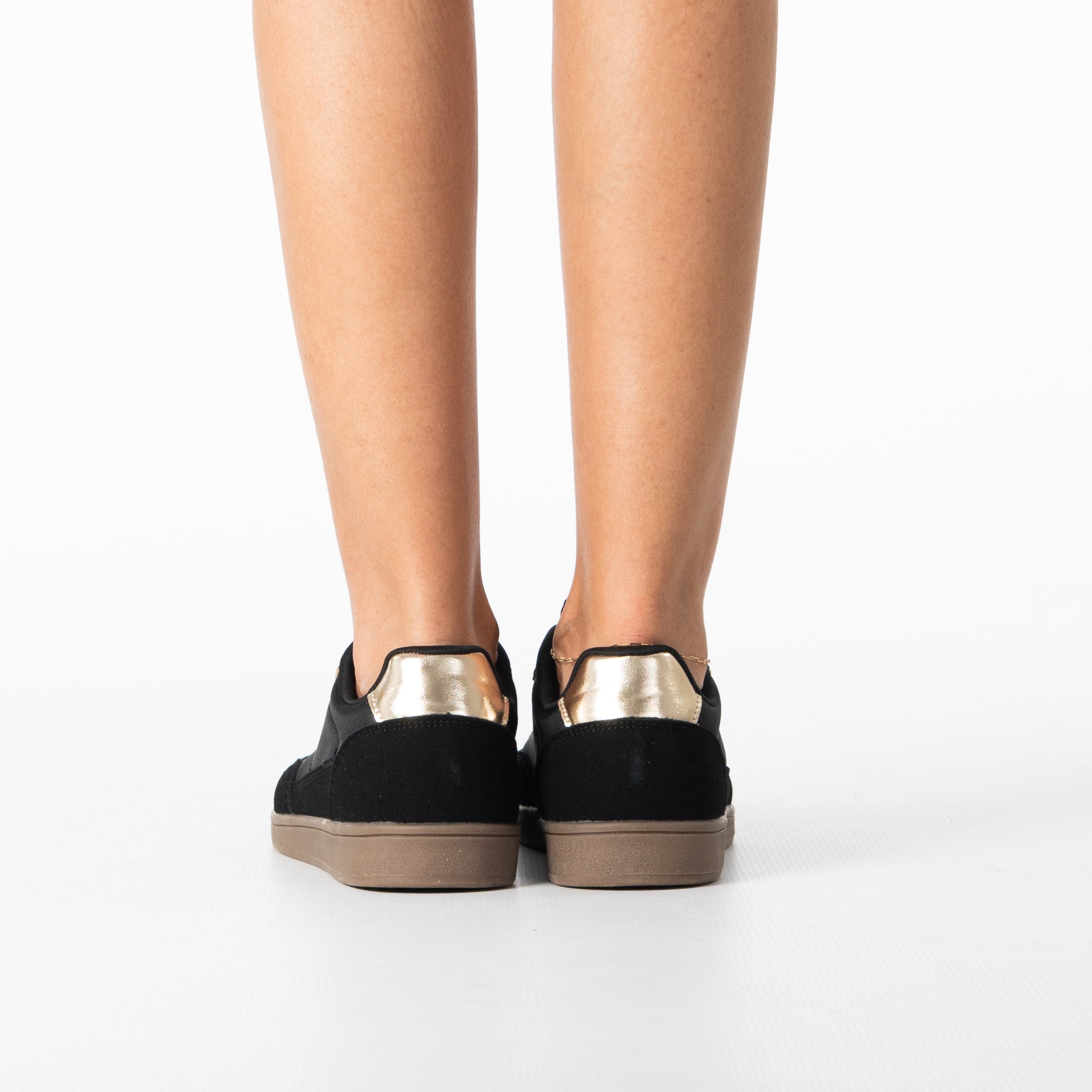 Uma women's sleek black sneaker with gold zip detail