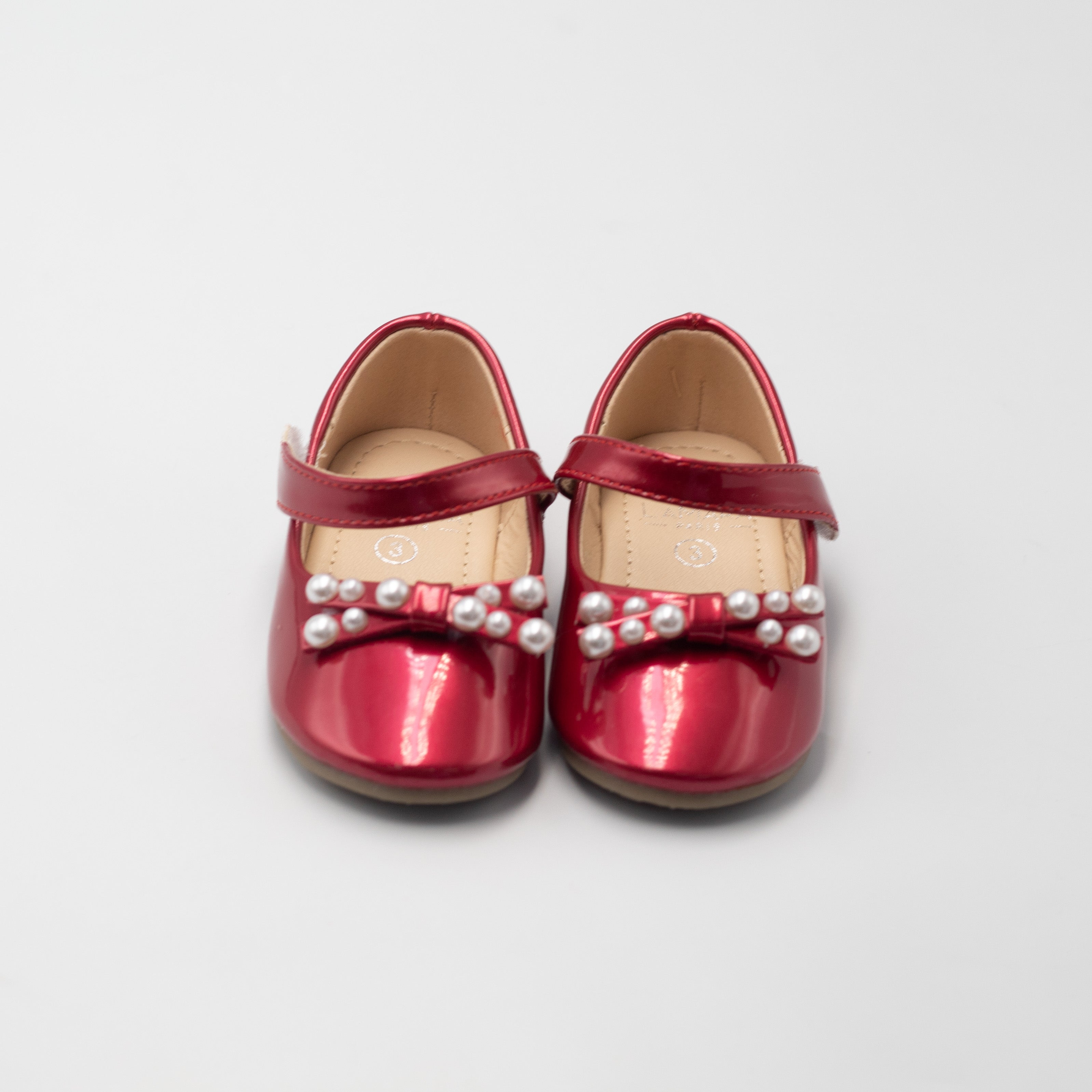 Afet baby girls patent pump with pearl on a bow red